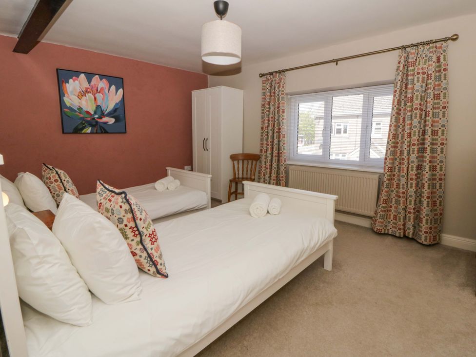 A bedroom with two single beds and a wardrobe at La Bastille in Maenclochog