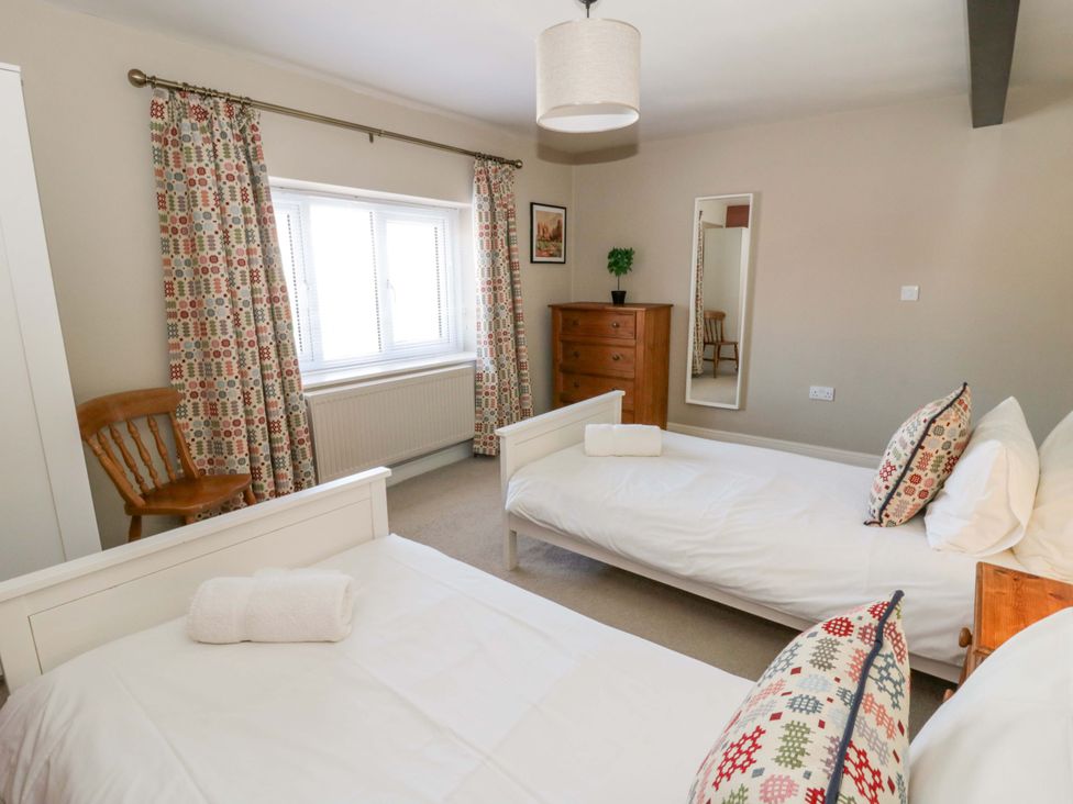 A bedroom with two beds and a dresser at La Bastille in Maenclochog