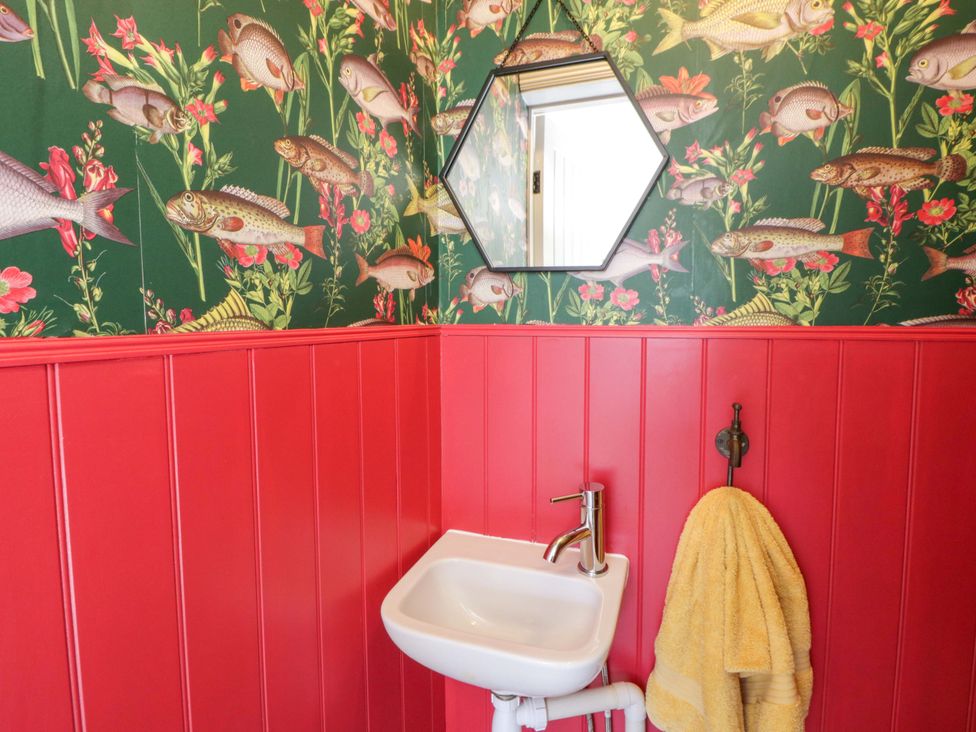 A bathroom with a sink and yellow towel at La Bastille in Maenclochog