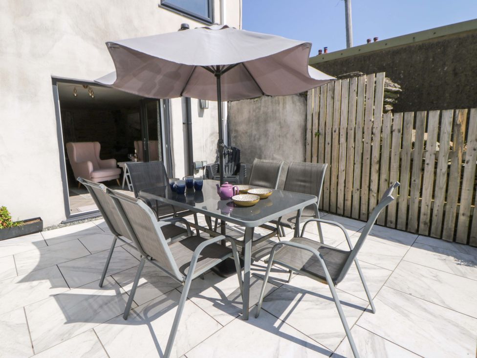 An outdoor dining area with a table and chairs at La Bastille in Maenclochog