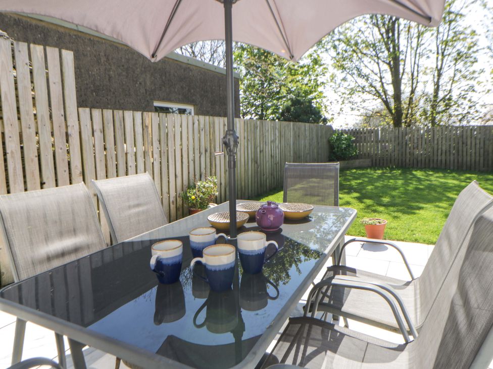 A garden dining area with table and chairs at La Bastille in Maenclochog