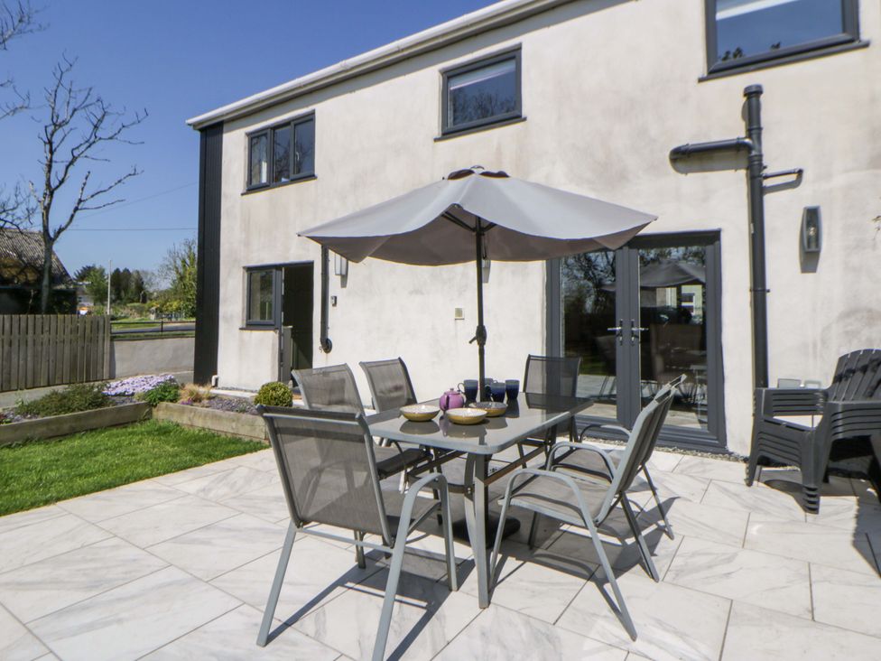 An outdoor dining area with a table and chairs at La Bastille in Maenclochog