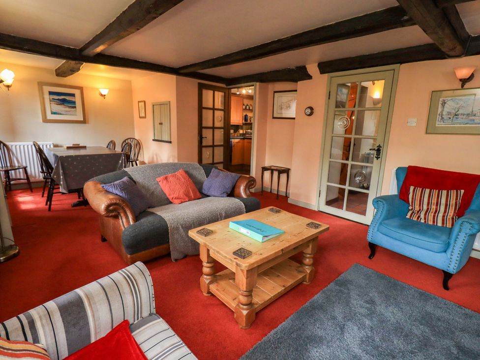 A living room with a sofa and coffee table at Tethera Cottage in Bampton, Cumbria