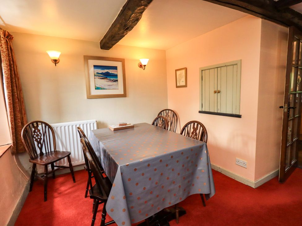 A dining room with a table and chairs at Tethera Cottage in Bampton, Cumbria