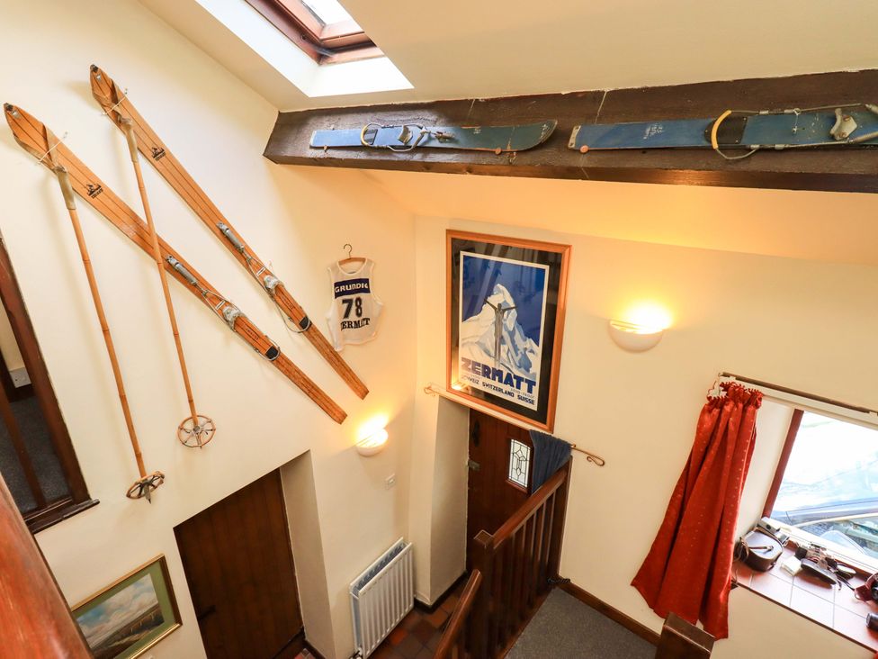A hallway with skis and a poster at Tethera Cottage in Bampton, Cumbria