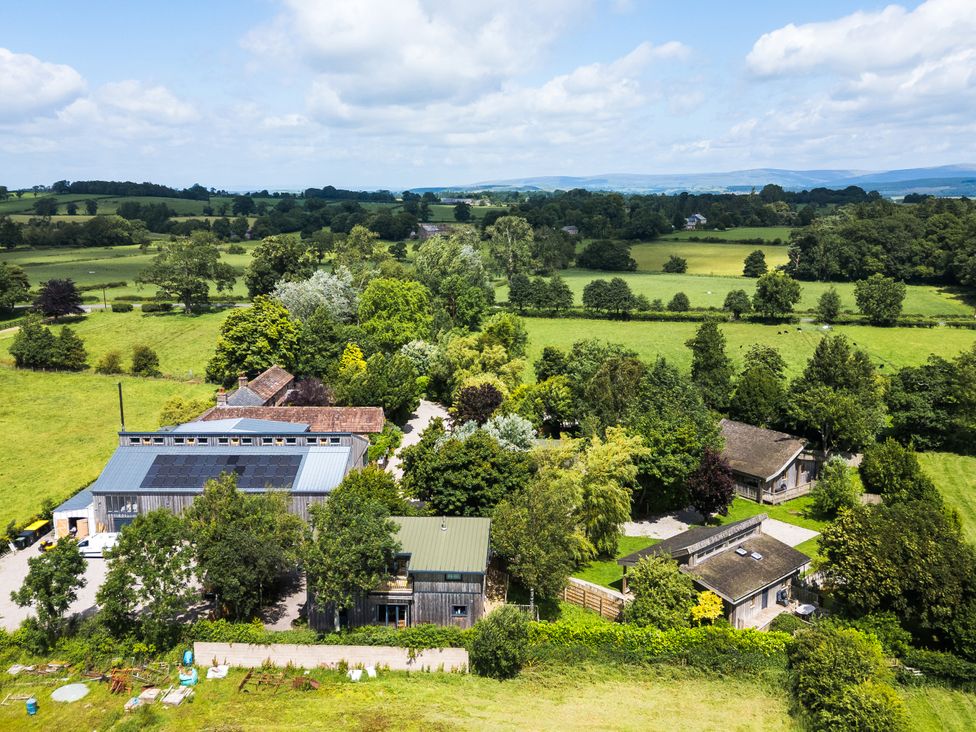 An aerial view of a farm surrounded by fields and trees at Barn Owl Cottage Hutton-in-the-Forest near Penrith
