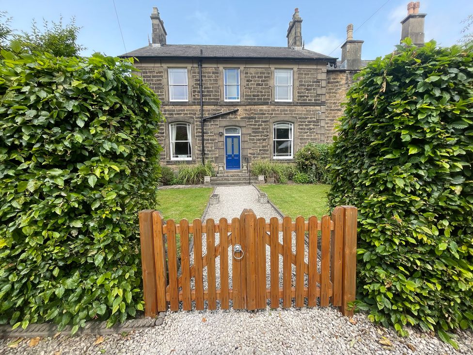 A house with a blue door and a wooden gate at Deeley House in Darley Dale