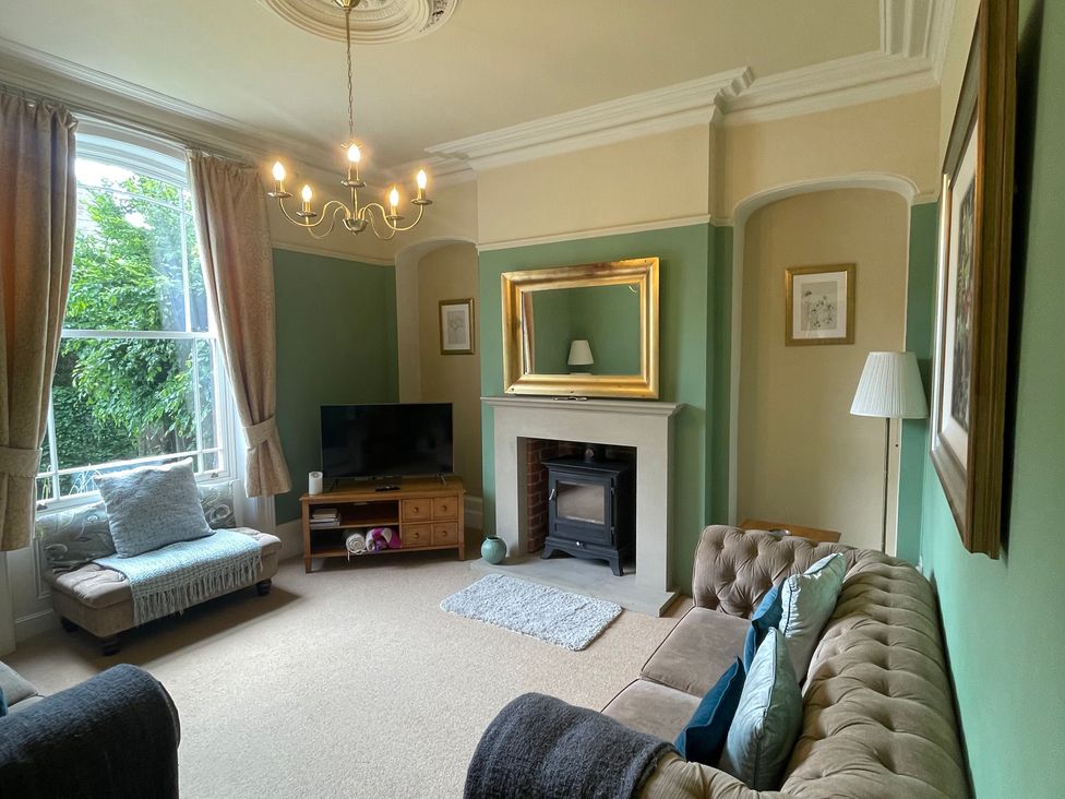 A living room with a television and a fireplace at Deeley House in Darley Dale