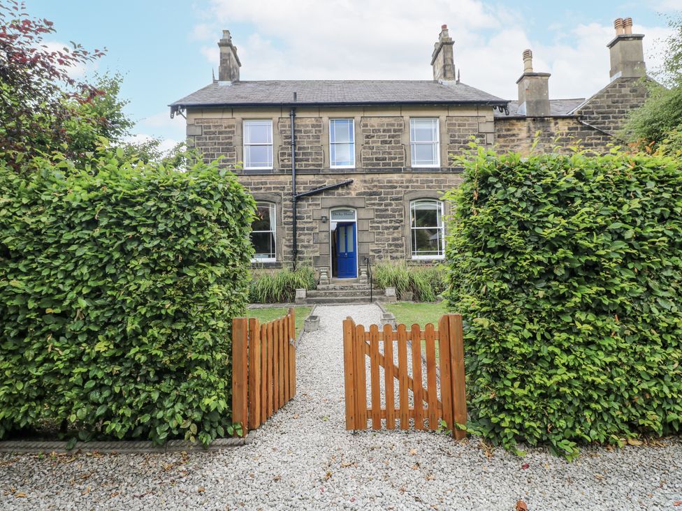 A house with a blue door and a gate at Deeley House Darley Dale