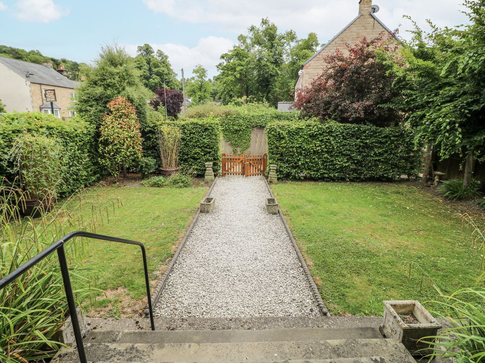 A garden with a gravel path and hedges at Deeley House in Darley Dale