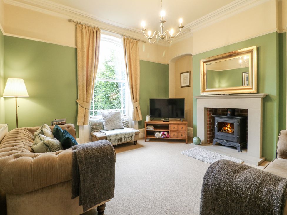 A living room with a television and a fireplace at Deeley House in Darley Dale
