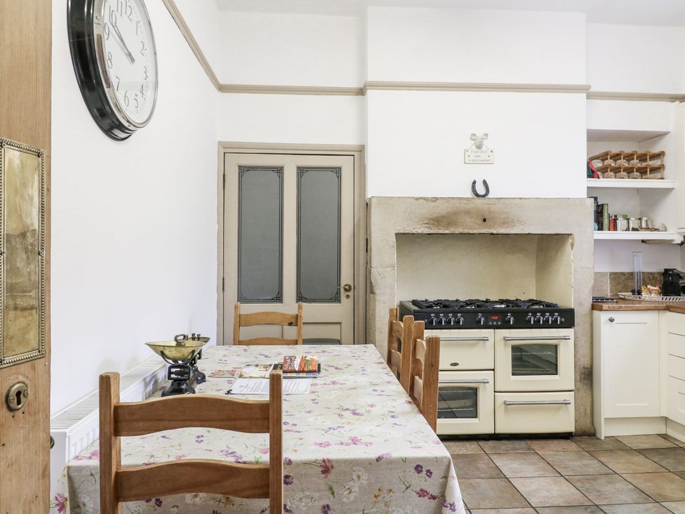 A kitchen with a wooden table and oven at Deeley House Darley Dale