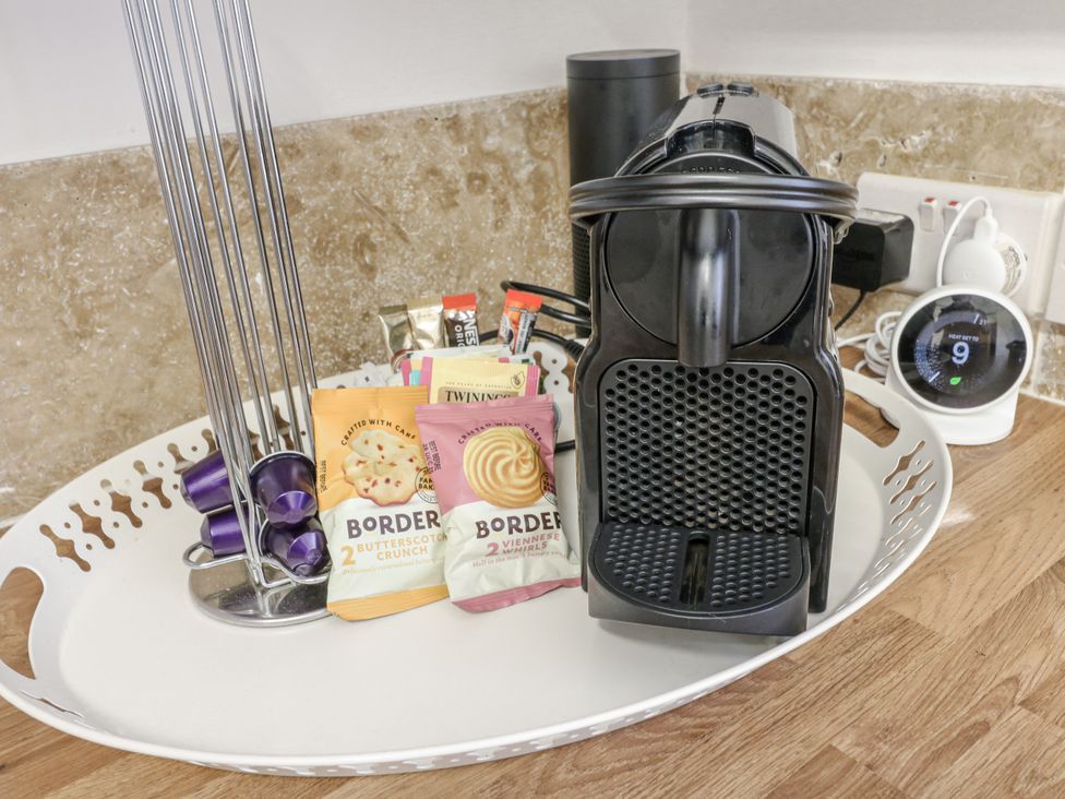 A kitchen with a coffee maker and snacks on a tray at Deeley House, Darley Dale