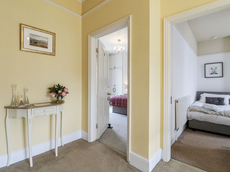 A hallway with a table and vases at Deeley House in Darley Dale
