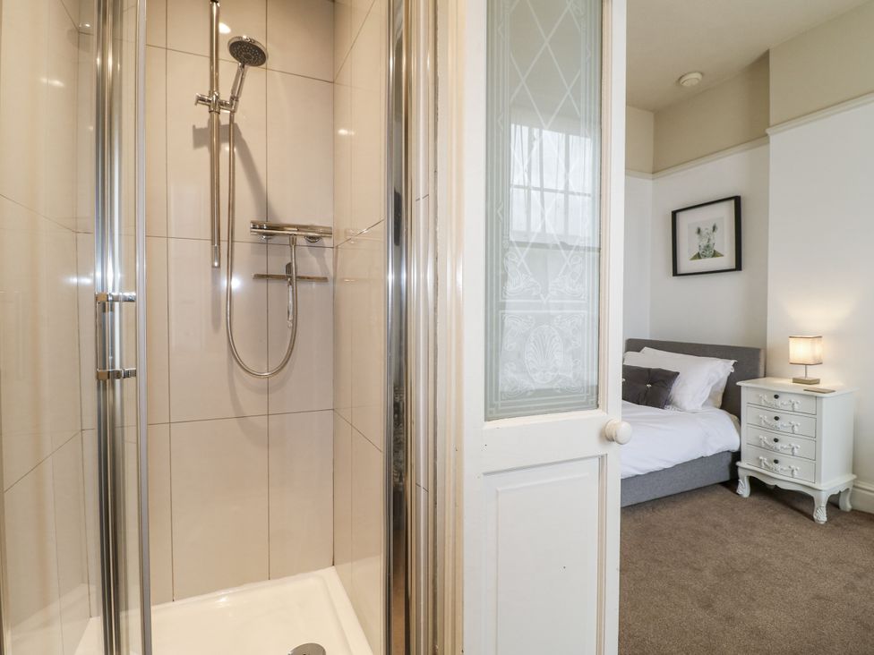 A bathroom with a shower and a view of a bedroom at Deeley House in Darley Dale