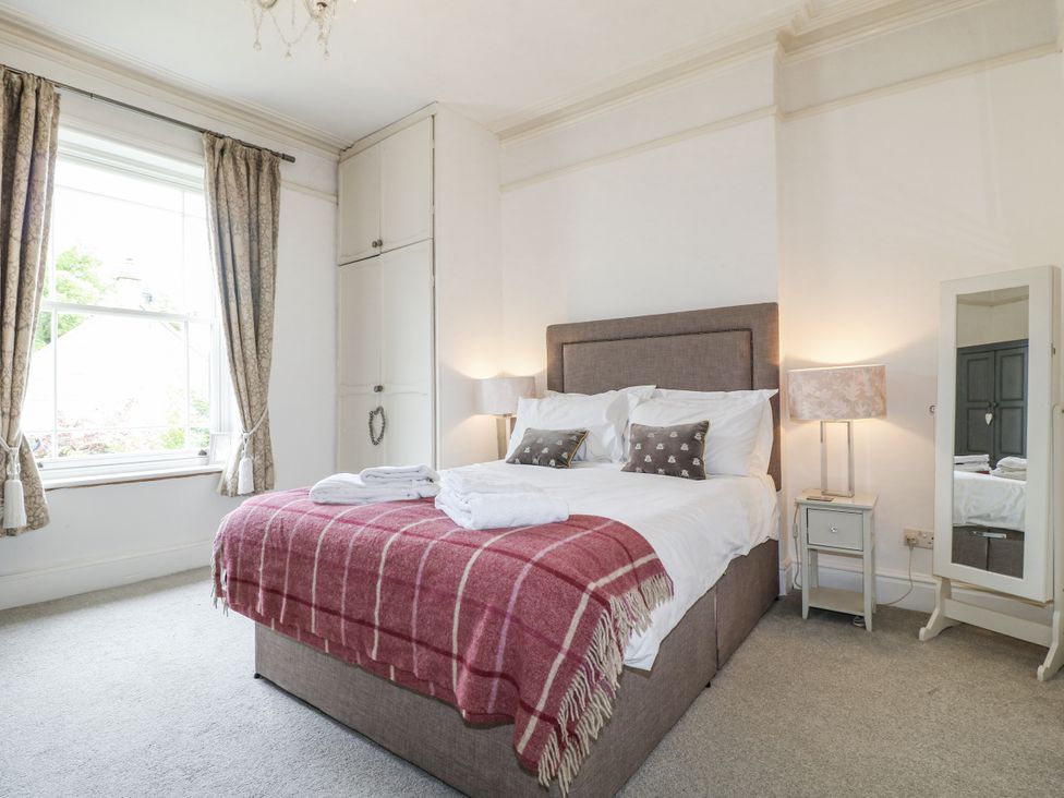 A bedroom with a bed and mirror at Deeley House in Darley Dale