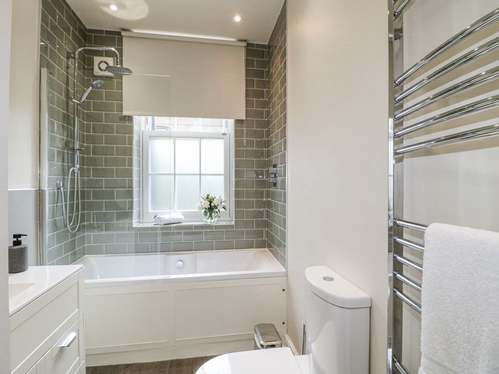A bathroom with a shower and bathtub at Deeley House in Darley Dale