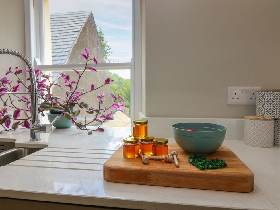 A kitchen with honey jars and an orchid plant at Ashlea in Oxton near Lauder