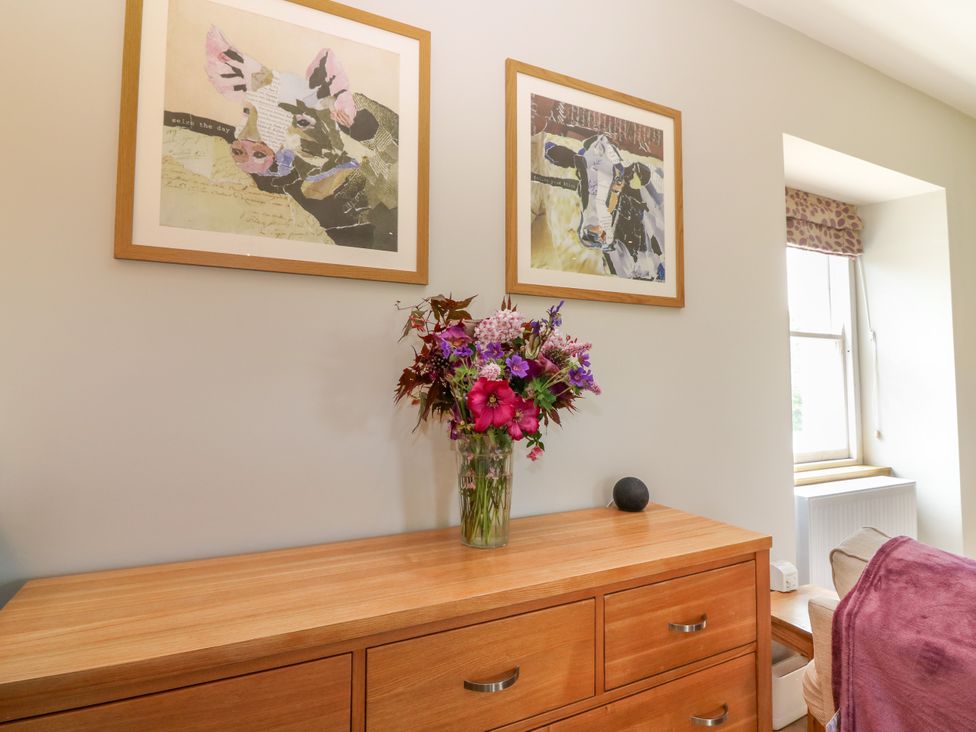A living room with decorative flowers and wall art at Ashlea in Oxton near Lauder