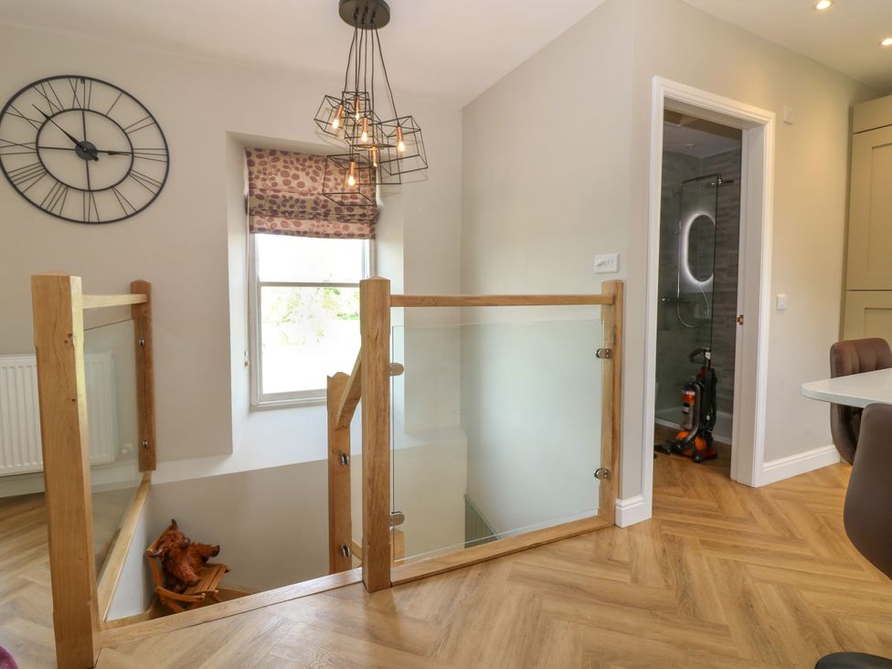 A hallway with a clock and staircase at Ashlea in Oxton near Lauder