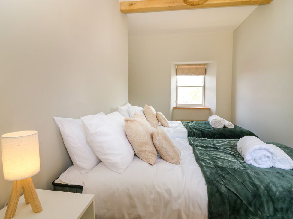 A bedroom with two beds and a lamp at Ashlea Oxton near Lauder