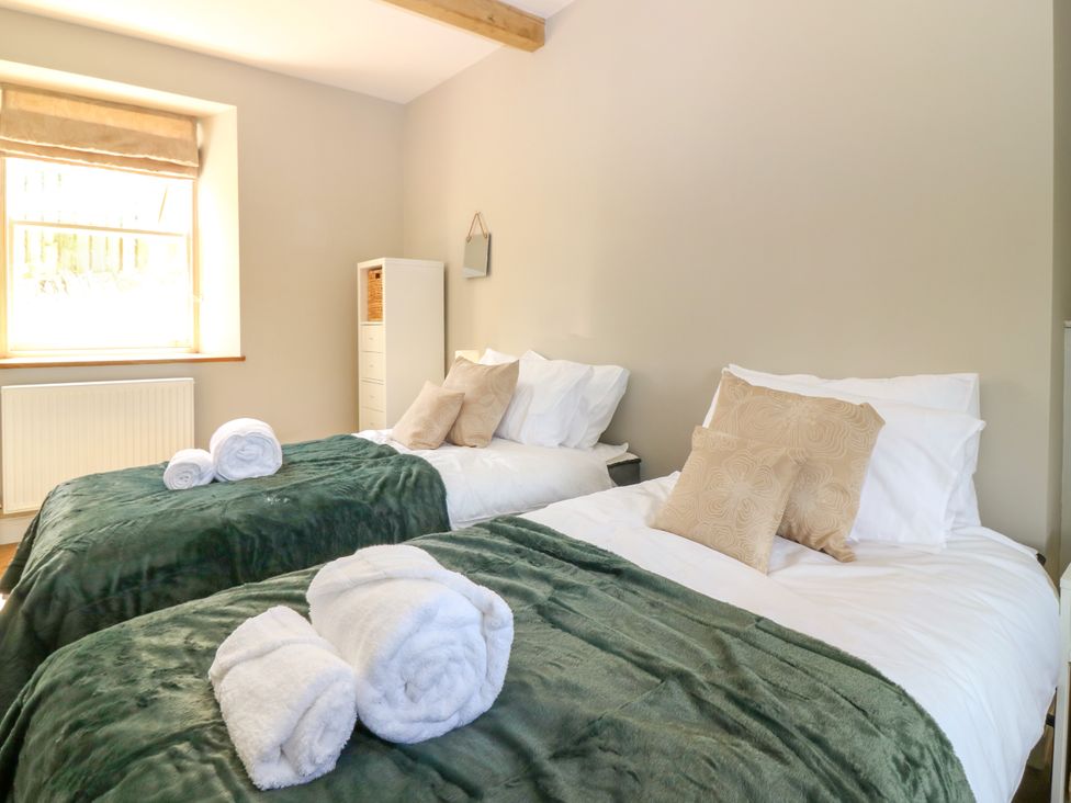 A bedroom with two beds and a window at Ashlea in Oxton near Lauder