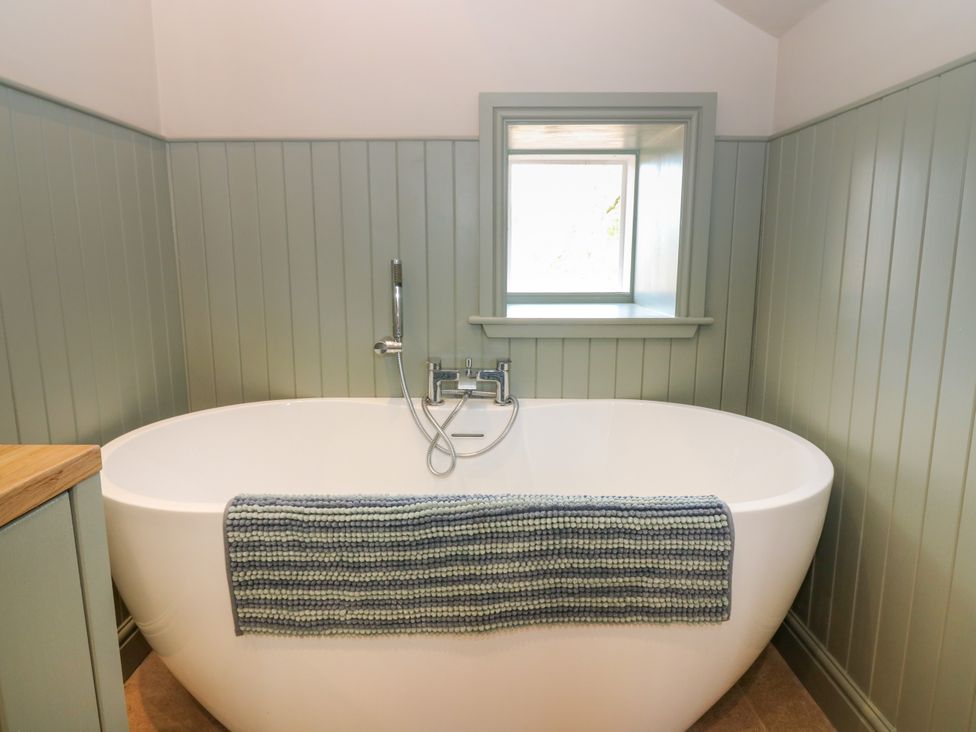 A bathroom with a bathtub and a window at Ashlea Oxton near Lauder