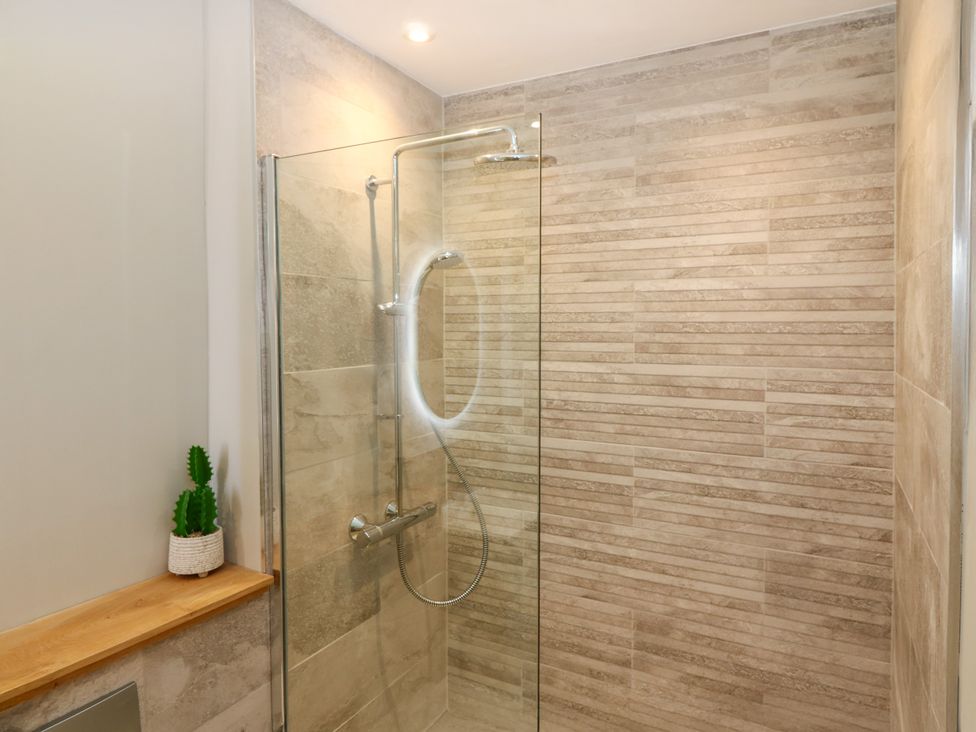 A shower with glass door and wall tiles at Ashlea Oxton near Lauder