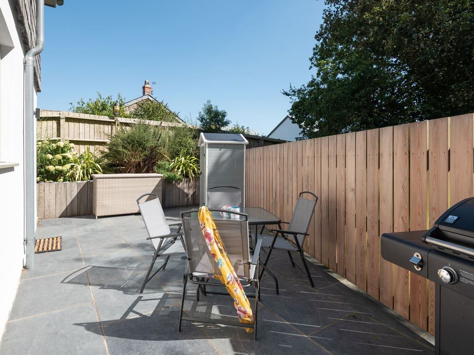 An outdoor area with a table and chairs at Pentire in St Minver