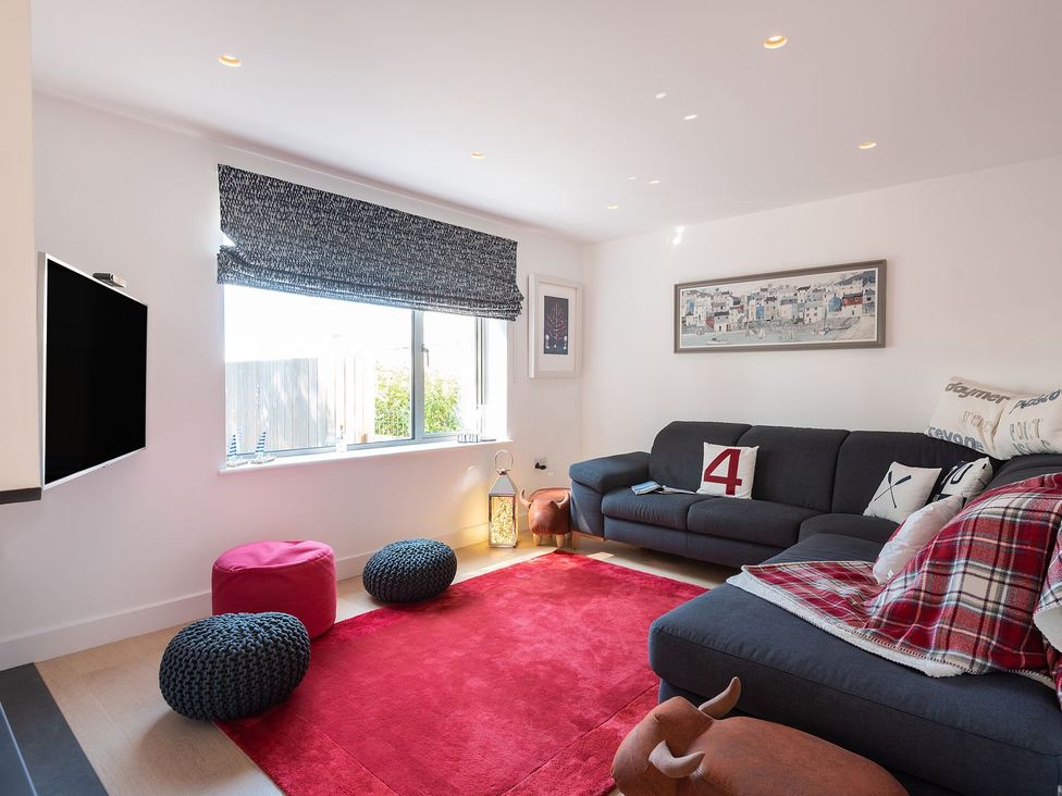 A living room with a sofa and television at Pentire in St Minver