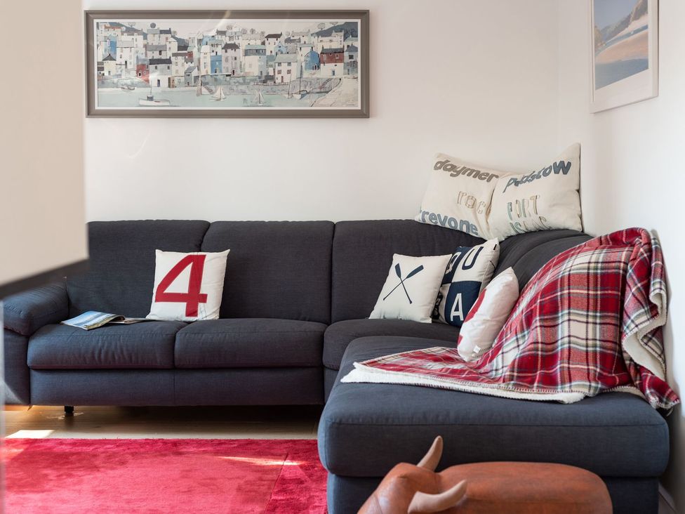 A living room with a sofa and cushions at Pentire St Minver