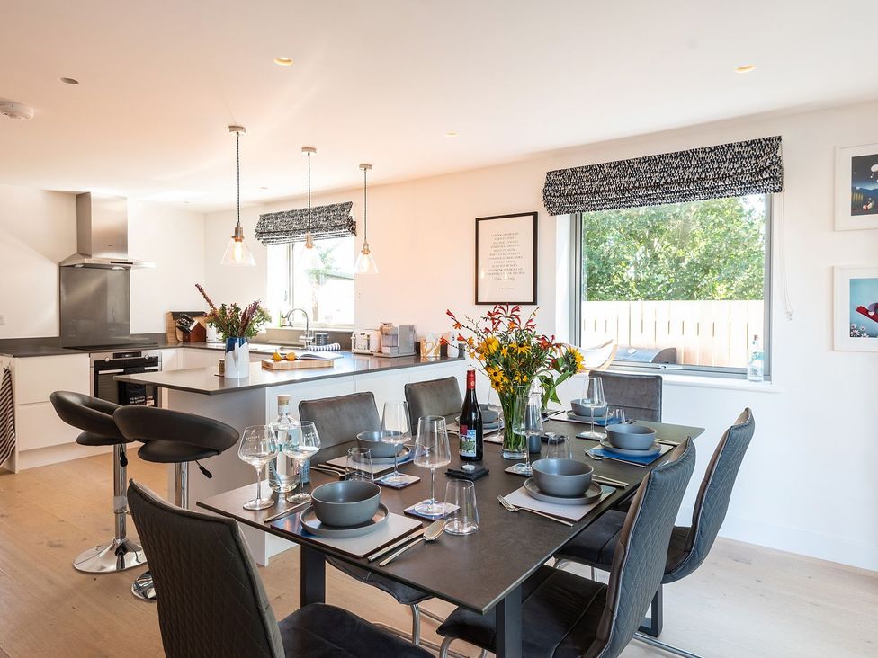 A kitchen with a dining table set for a meal at Pentire in St Minver