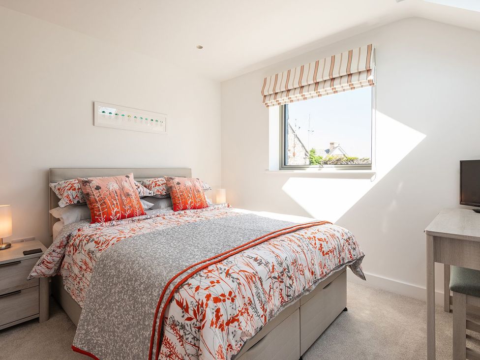 A bedroom with a bed and bedside table at Pentire, St Minver