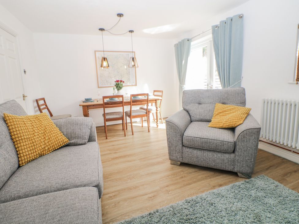A living room with a sofa and dining area at 6 Fidlers Close in Bamford