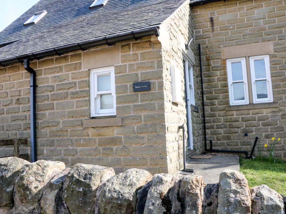 A stone building with windows and a door at Win Hill View in Bamford