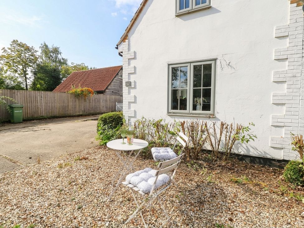 A patio with a table and chairs at Horseshoe Stable in Mattishall