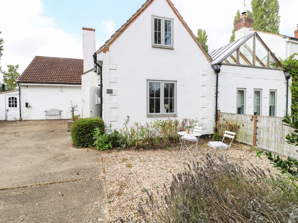 An outdoor area with a house, table, and chairs at Horseshoe Stable in Mattishall