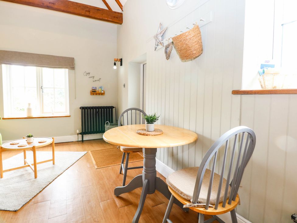 A dining room with a table and two chairs at Horseshoe Stable in Mattishall