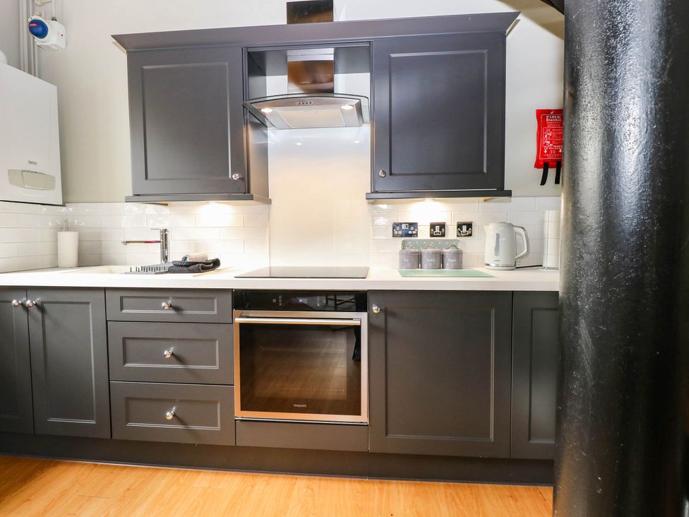 A kitchen with dark cabinets and stainless steel appliances at Horseshoe Stable in Mattishall