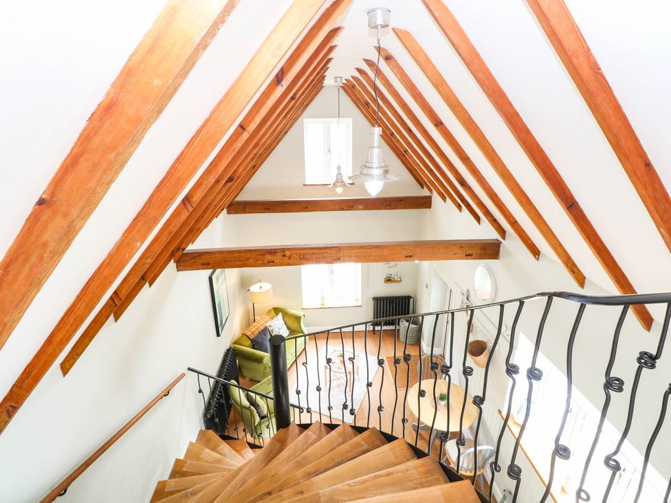 A living room with a staircase and furniture at Horseshoe Stable in Mattishall