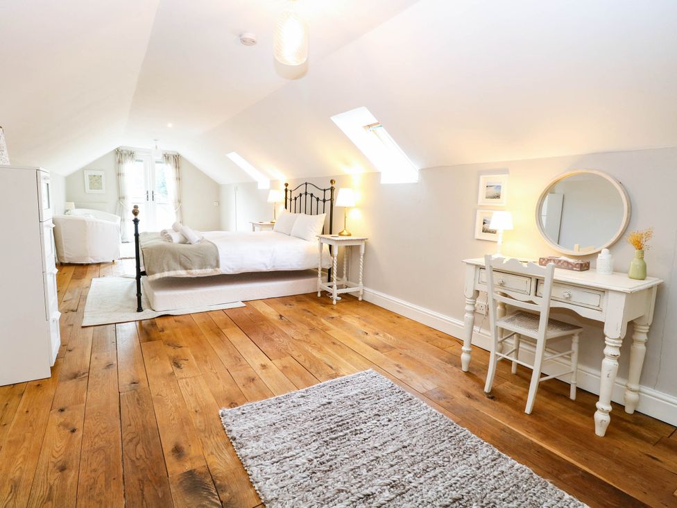 A bedroom with a bed and dressing table at Horseshoe Stable in Mattishall