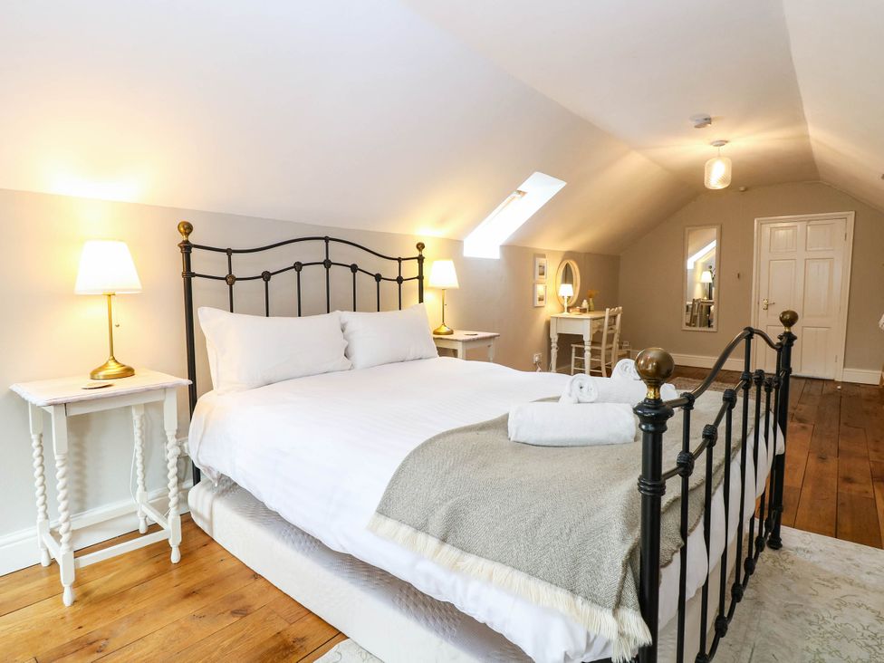 A bedroom with a double bed and nightstand at Horseshoe Stable in Mattishall