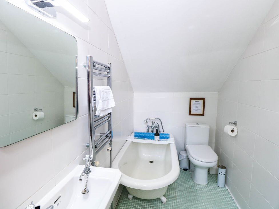 A bathroom with a bathtub, toilet, and sink at Horseshoe Stable in Mattishall