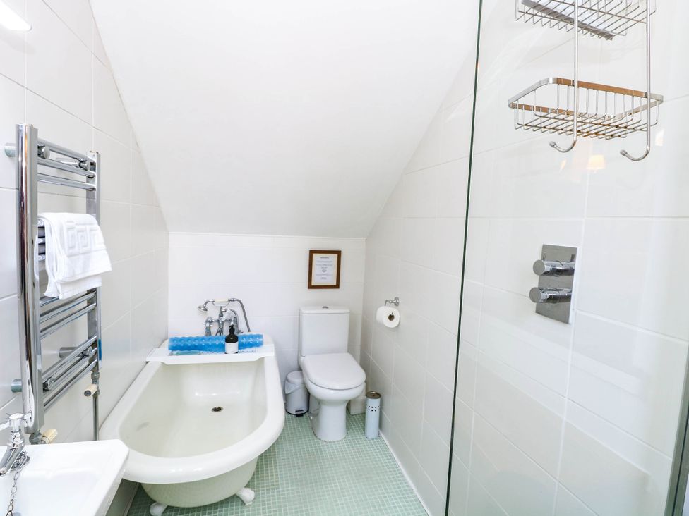 A bathroom with a bathtub, toilet, and shower at Horseshoe Stable in Mattishall