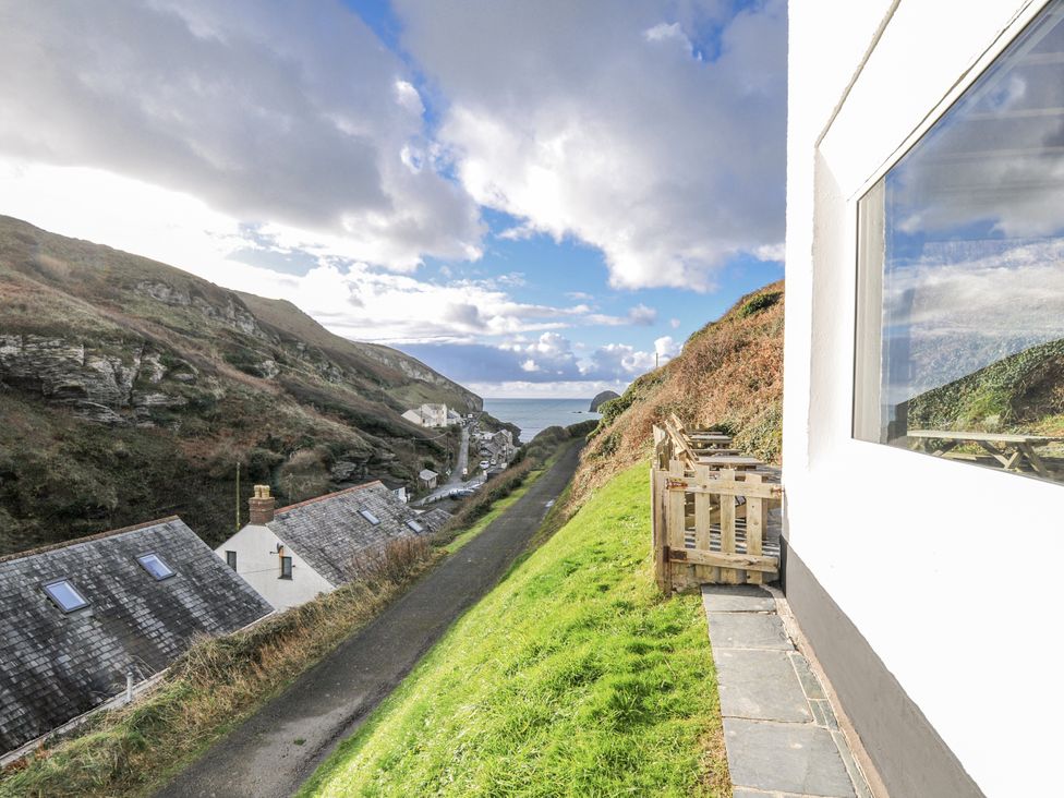 An outdoor view showing a pathway and houses near the sea at Little Ruffo in Trebarwith near Tintagel