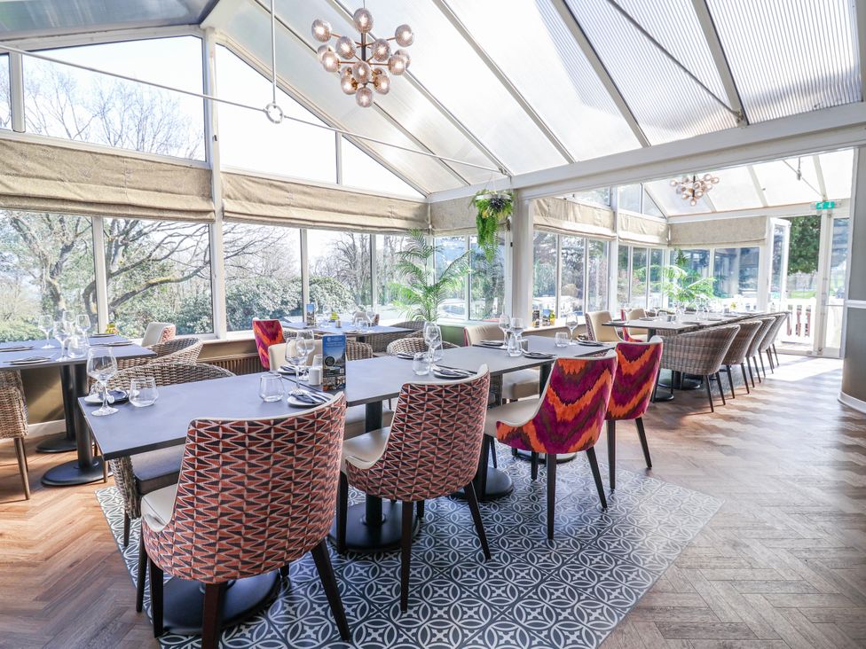 A dining room with tables and chairs at Woodlands Gold (WO 41) in Ruthin