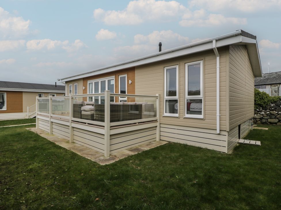 A house with a deck and grass in front at Platinum Lodge (503) Talybont