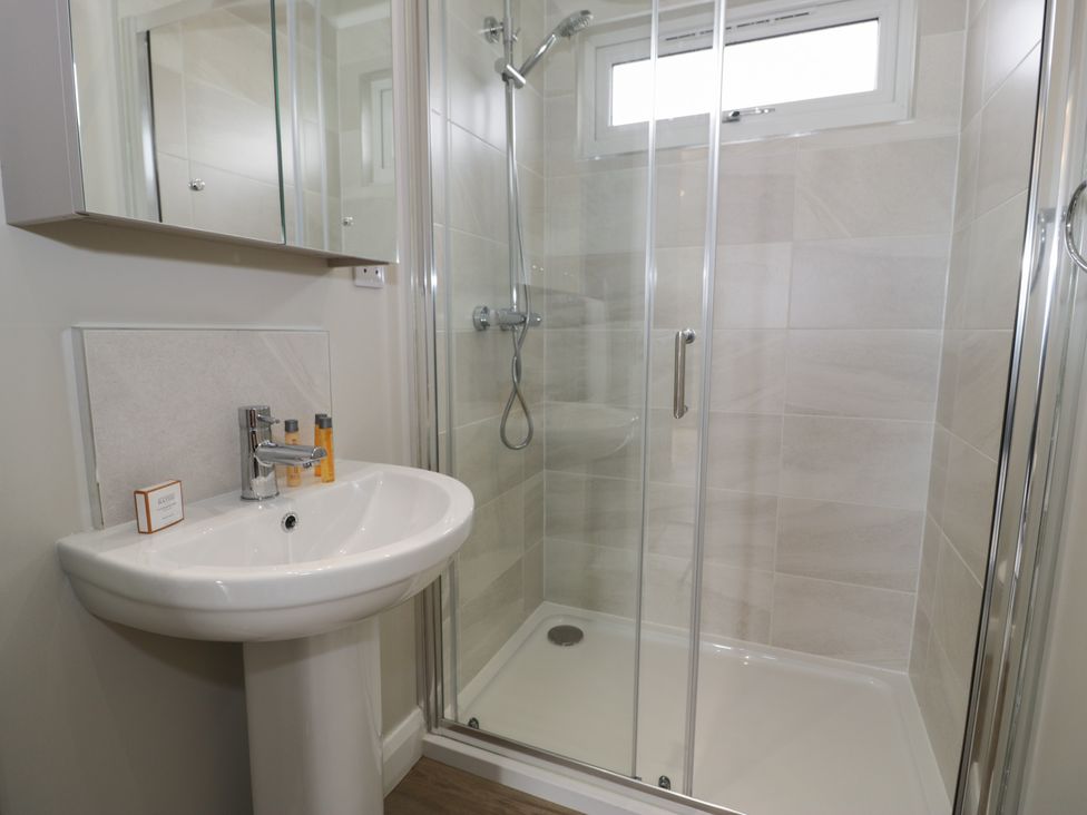 A bathroom with a shower and sink at Platinum Lodge (503) Talybont