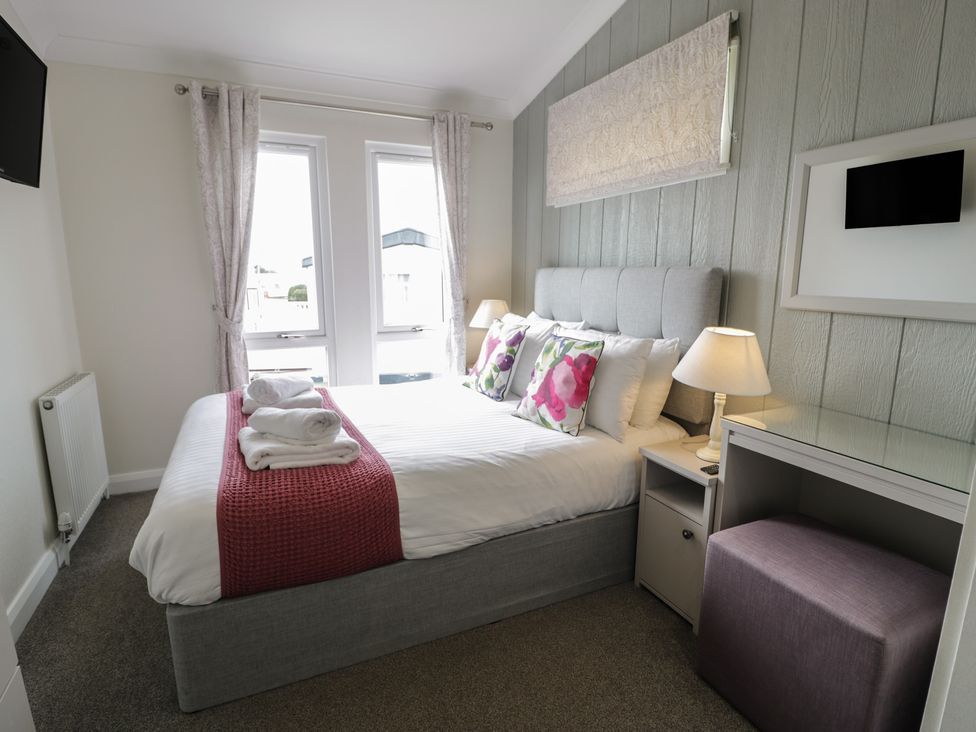 A bedroom with a bed and windows at Platinum Lodge (503) Talybont