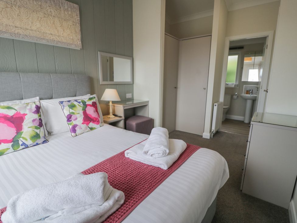 A bedroom with a bed and attached bathroom at Platinum Lodge (503) Talybont